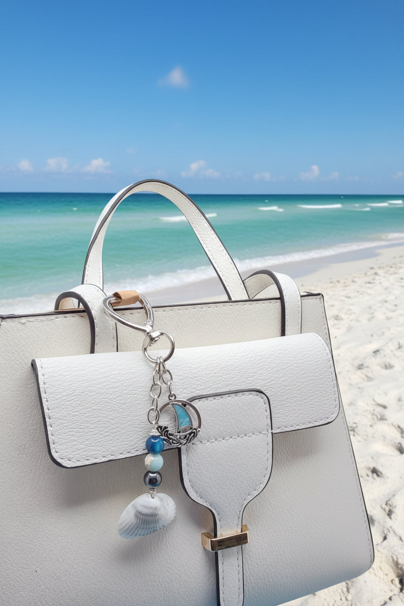 Coastal sailboat scallop shell bag charm on white bag showing sailboat charm detail