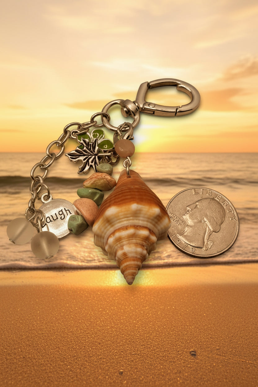 Florida conch shell Laugh bag charm with quarter for scale on blue background showing heart clasp