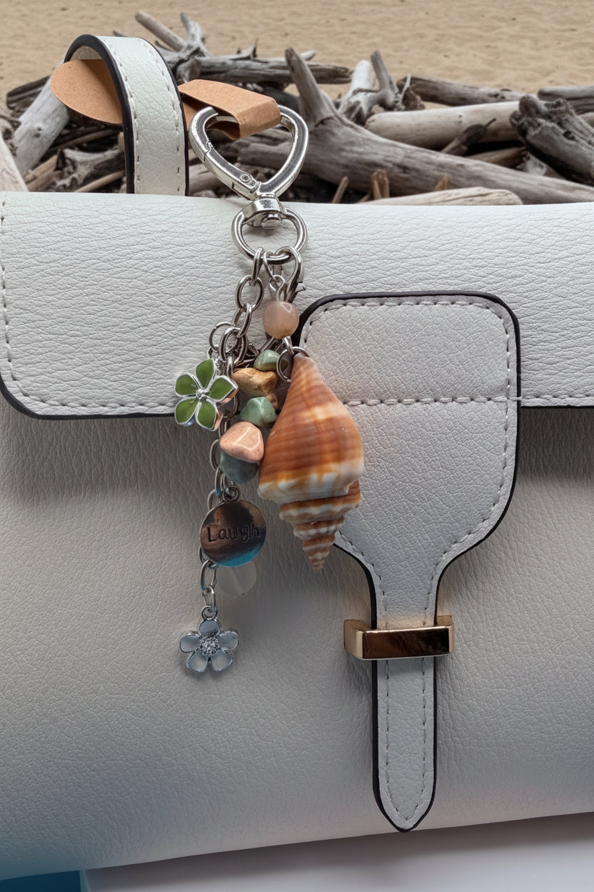 Florida conch shell Laugh bag charm on white structured handbag with blue shell print background