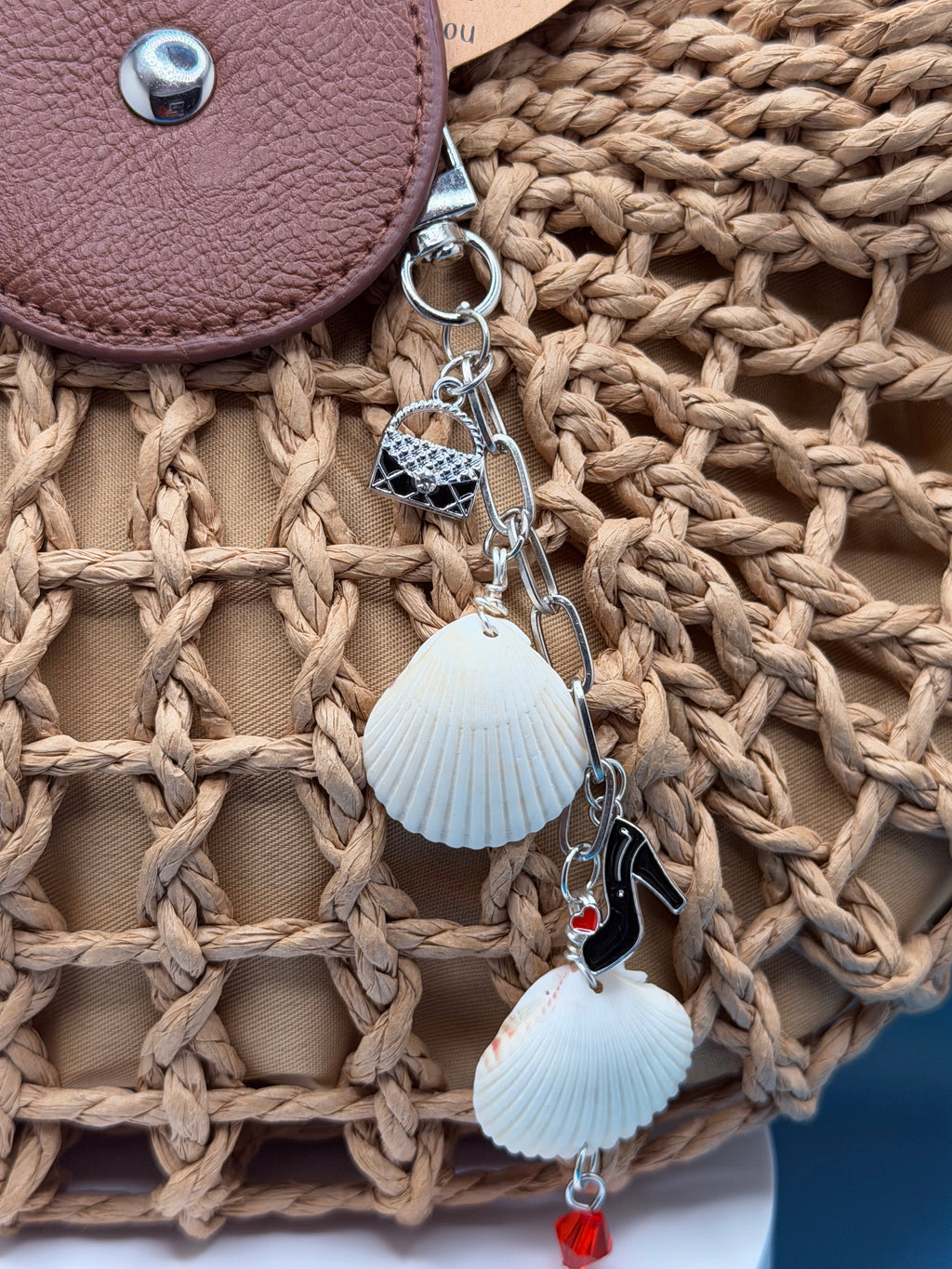 Shells and Stilettos scallop shell bag charm with quarter for scale on blue background showing red crystal drop