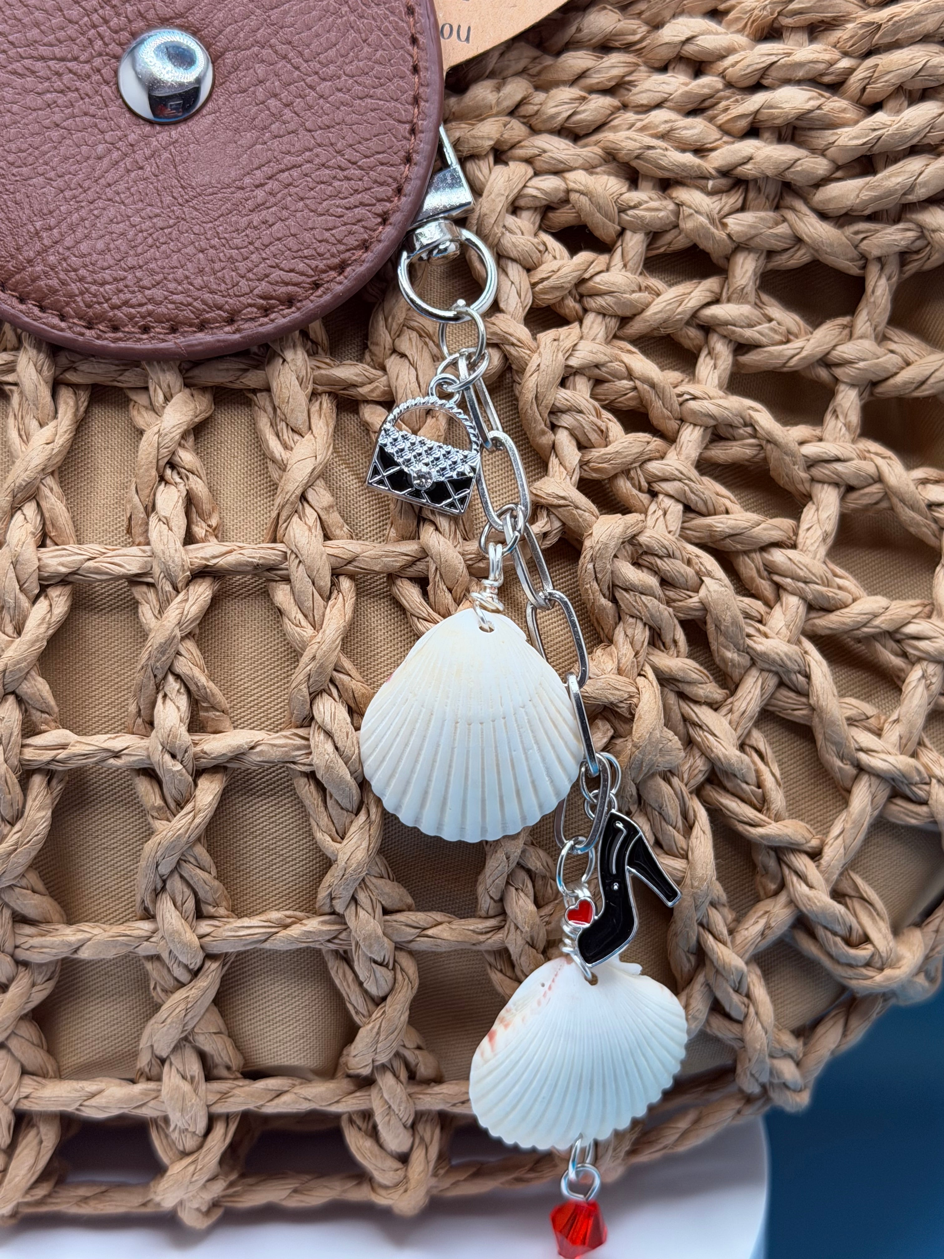 Shells and Stilettos scallop shell bag charm with quarter for scale on blue background showing red crystal drop
