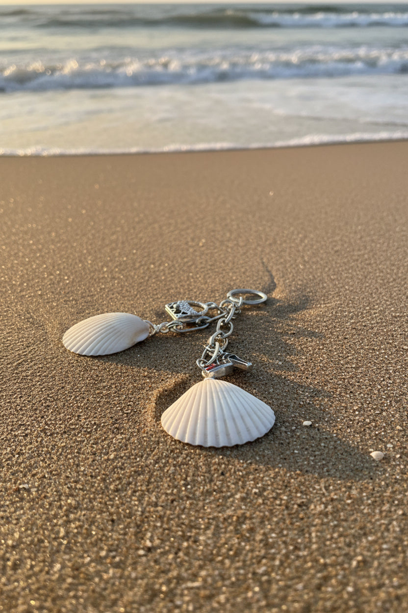 Shells and Stilettos scallop shell bag charm close-up on blue background showing crystal handbag charm detail