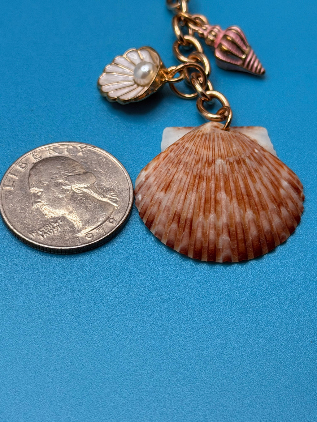 Chocolate seashell bag charm close-up on woven straw bag