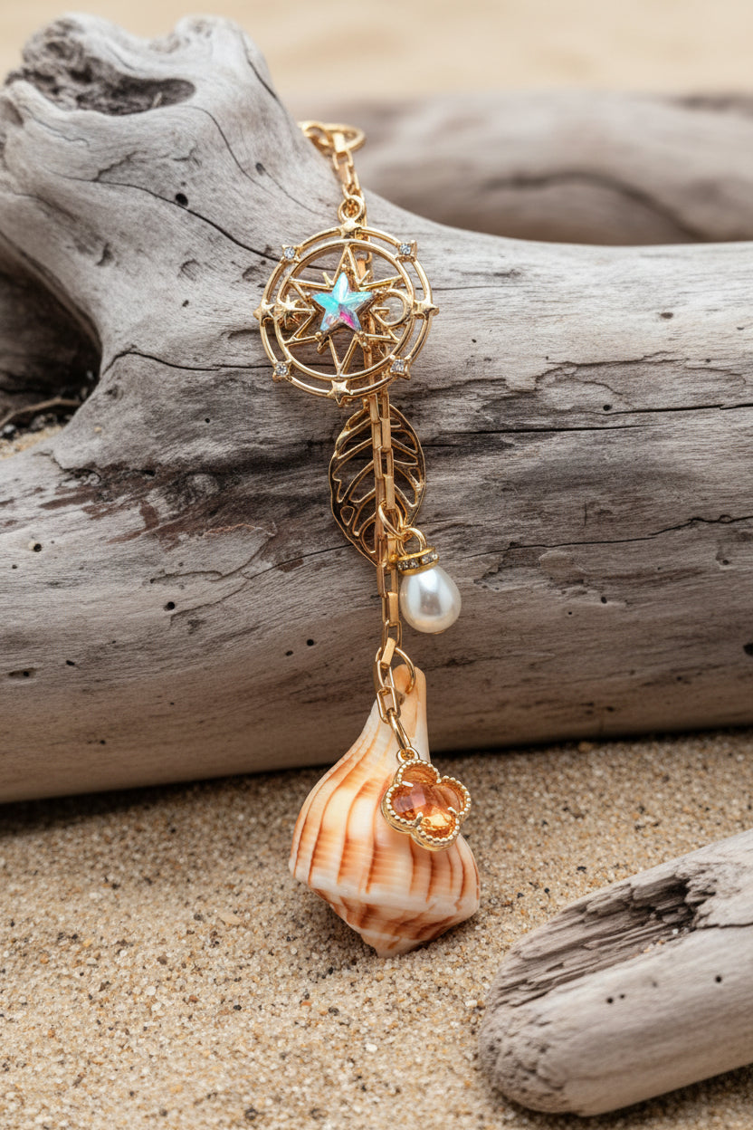 Celestial Shores lightning whelk shell bag charm styled on woven straw bag showing compass star charm