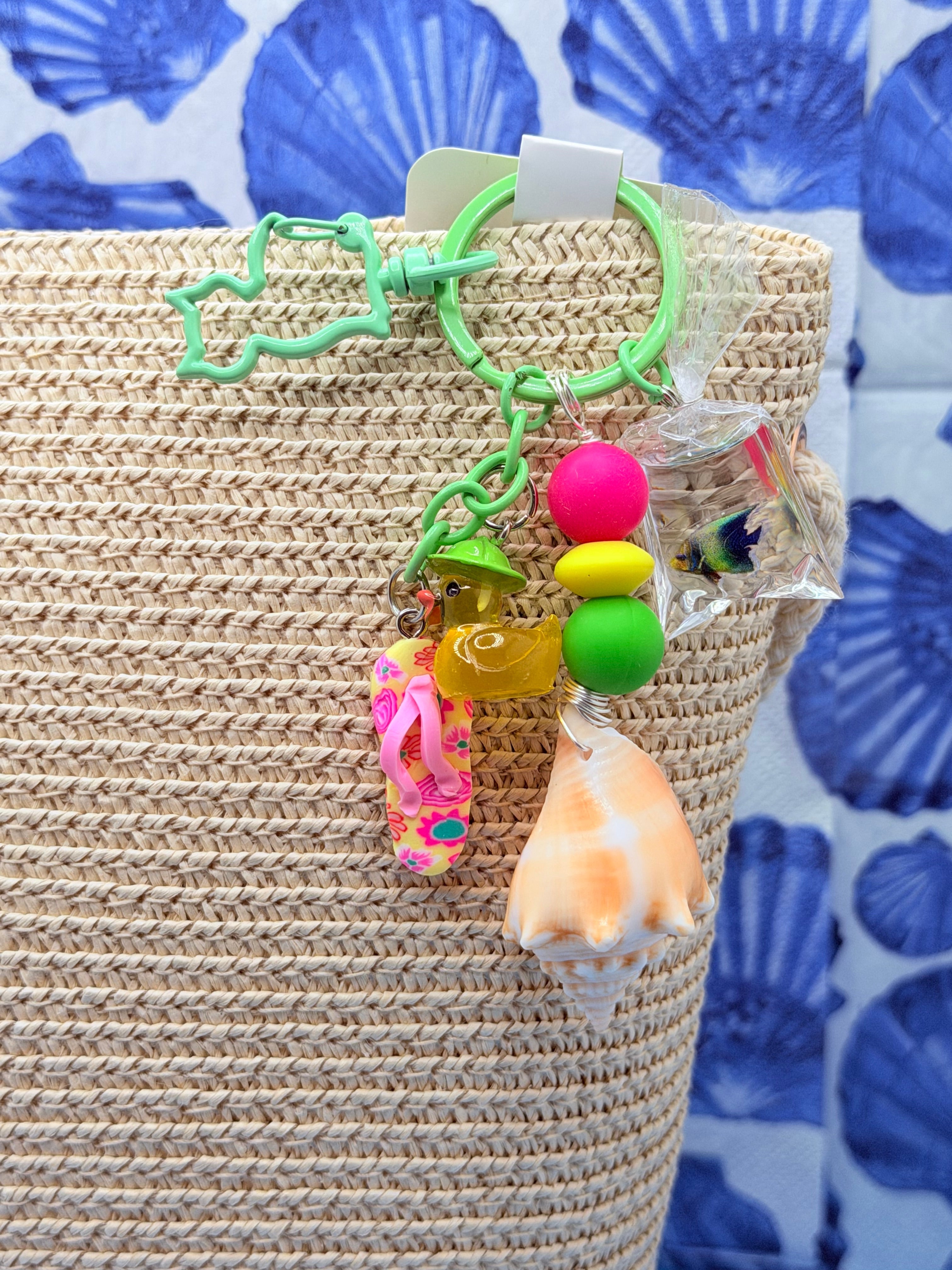 Florida Fighting Conch bag charm hanging on woven straw tote bag
