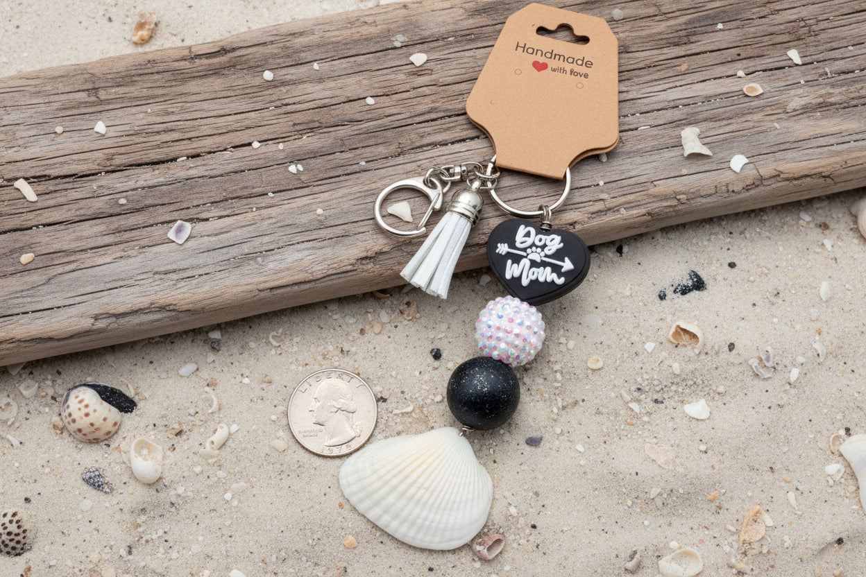 Dog Mom ark shell keychain with quarter for scale on blue background showing full keychain