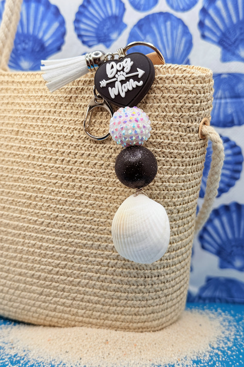 Dog Mom ark shell keychain on woven straw bag showing white tassel and lobster clasp