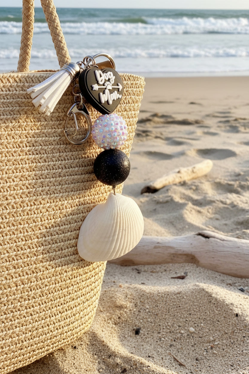 Dog Mom ark shell keychain on woven straw bag full view with shell print background