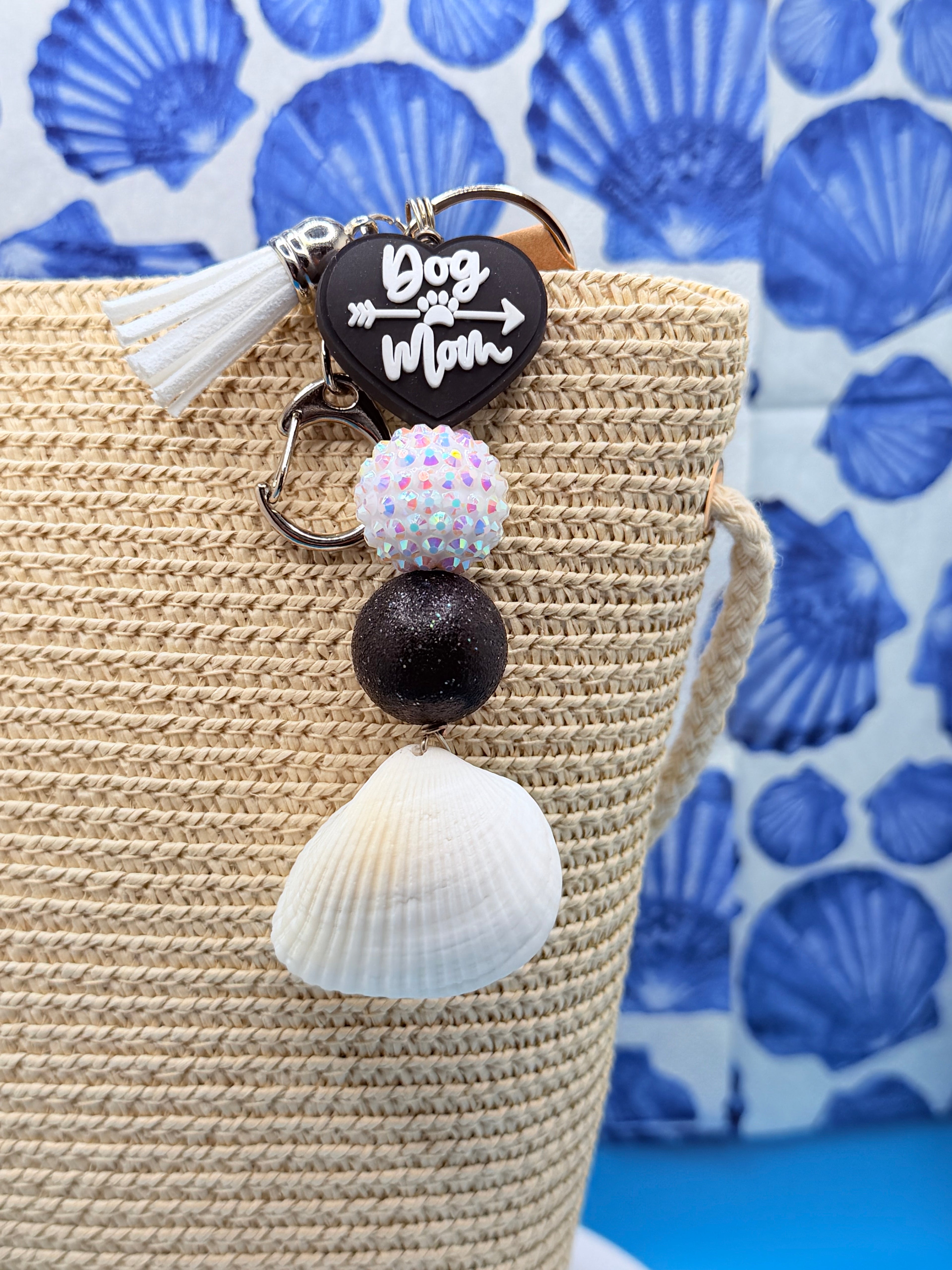 Dog Mom ark shell keychain on woven straw bag close-up showing ark shell and black glitter bead