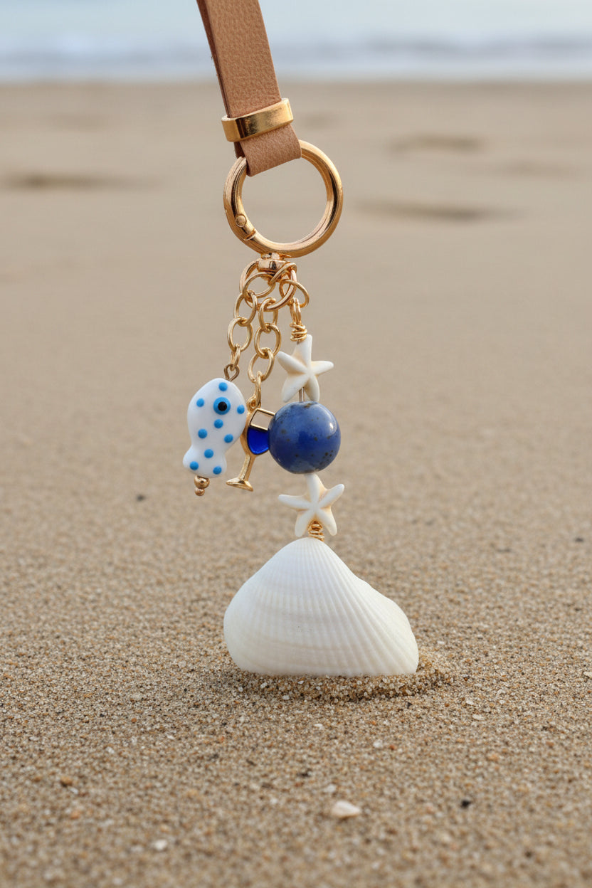 Florida ark shell bag charm styled on woven straw tote bag with blue shell print background