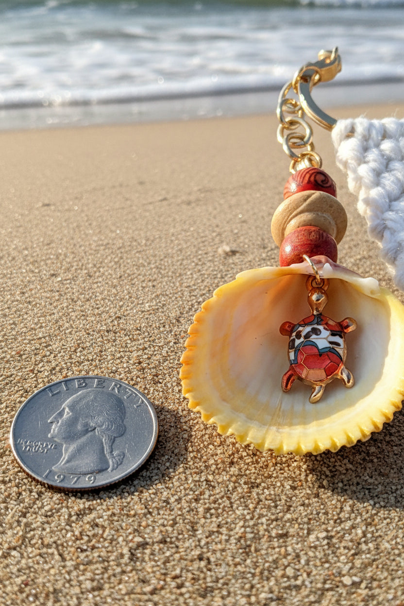 Turtle Cove prickly cockle shell macrame keychain styled on woven straw bag with shell print background