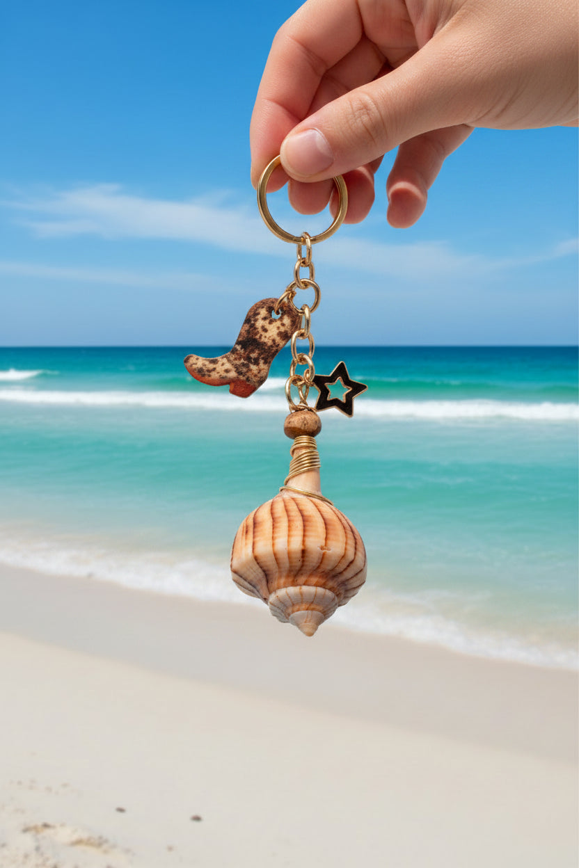 Boots and the Shore lightning whelk shell bag charm close-up on white handbag showing cowboy boot and star charm detail