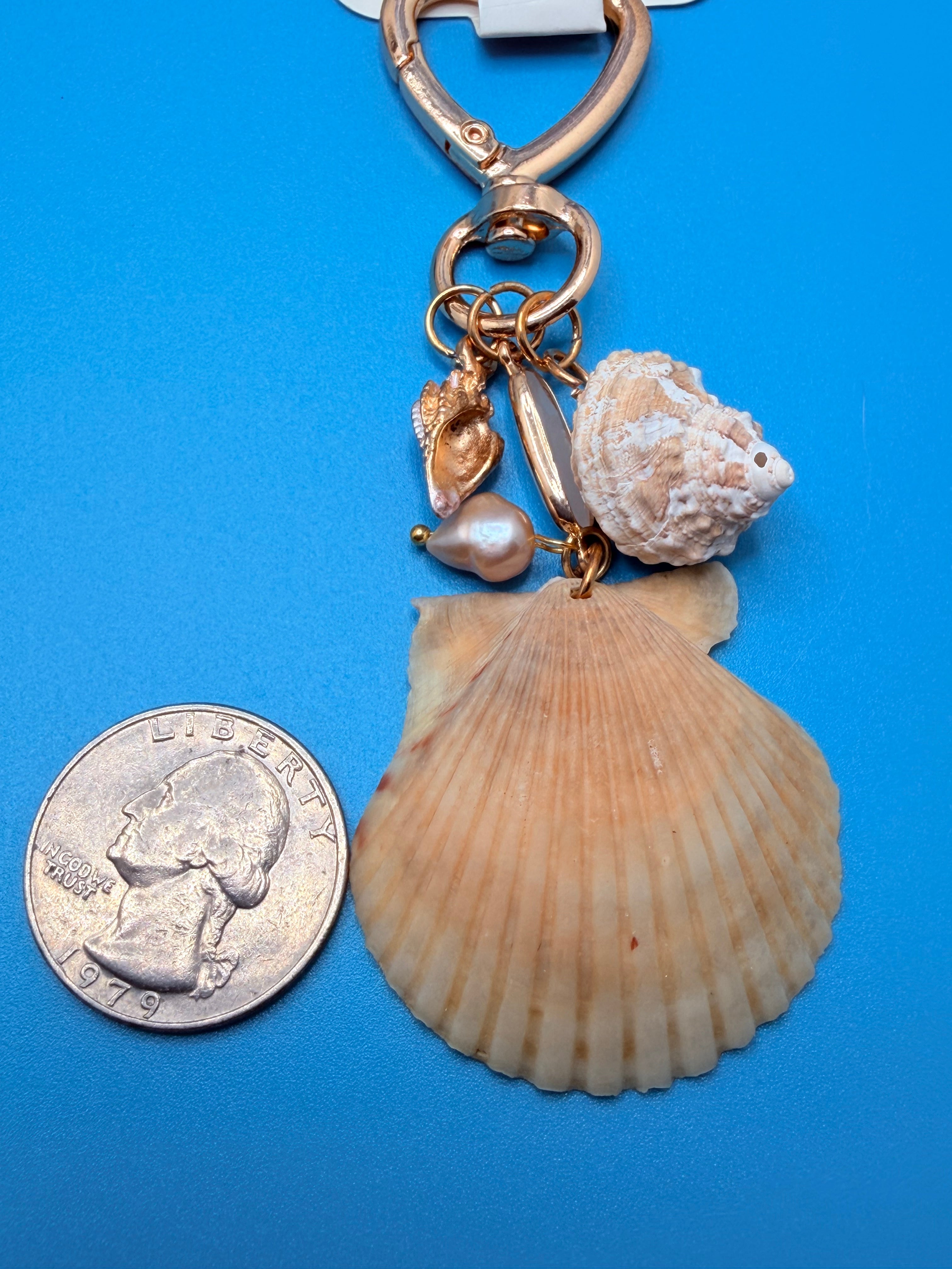 Dual Shores bag charm full view on white tote with blue shell print background