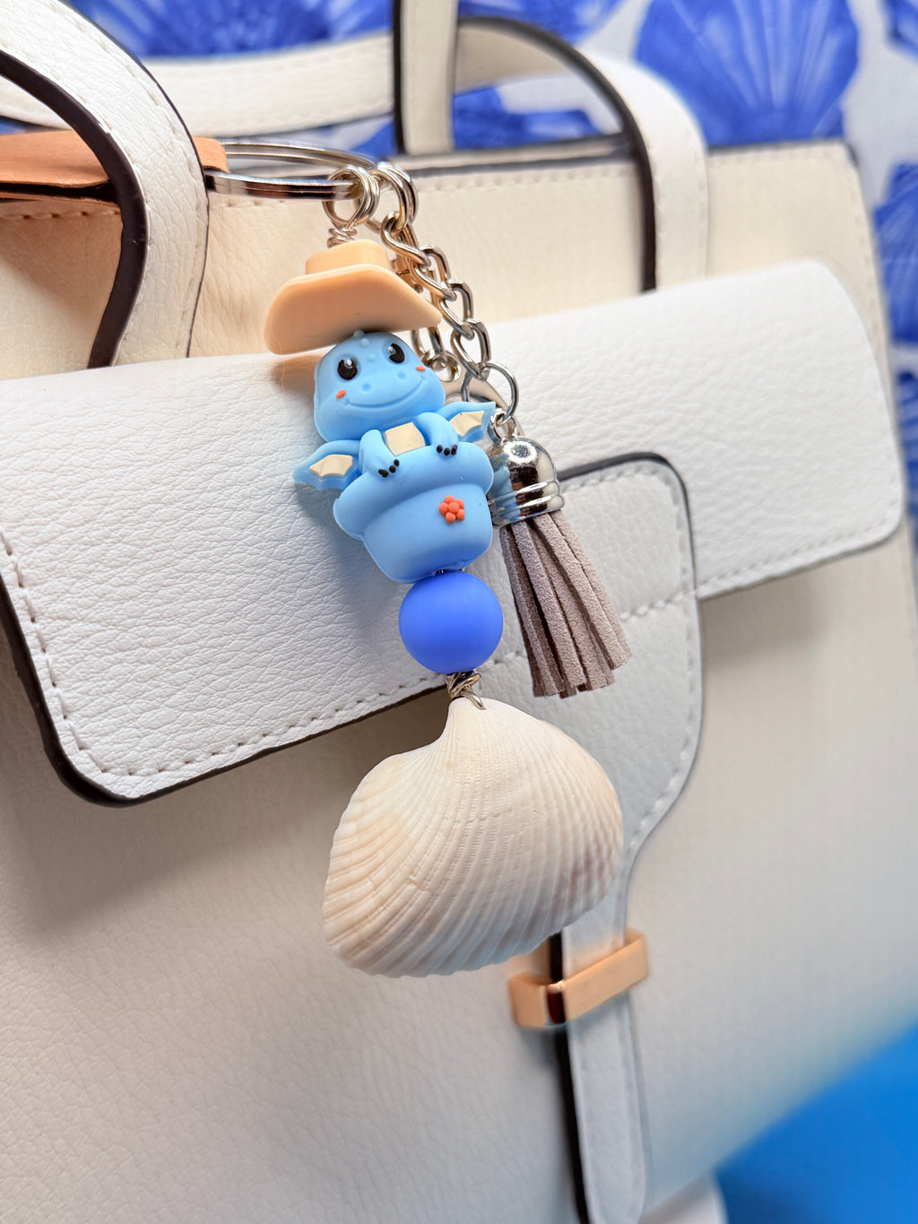 Cowboy Dragon ark shell keychain with quarter for scale on blue background showing ark shell close-up