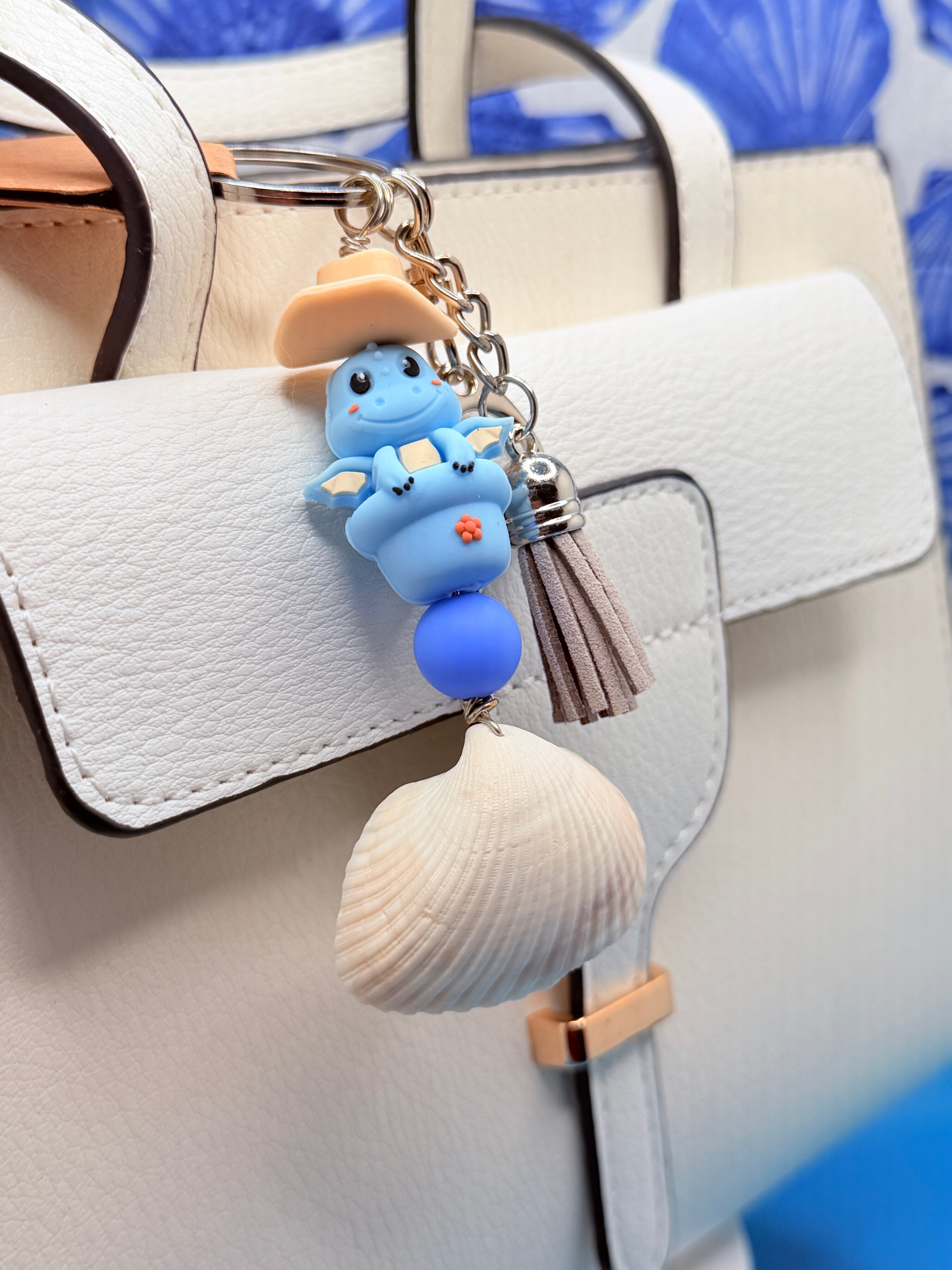 Cowboy Dragon ark shell keychain with quarter for scale on blue background showing ark shell close-up