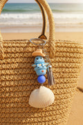 Cowboy Dragon ark shell keychain with quarter for scale on blue background showing full keychain back view