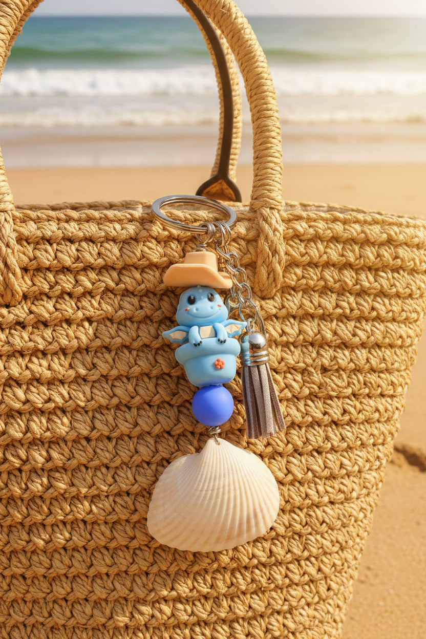 Cowboy Dragon ark shell keychain with quarter for scale on blue background showing full keychain back view
