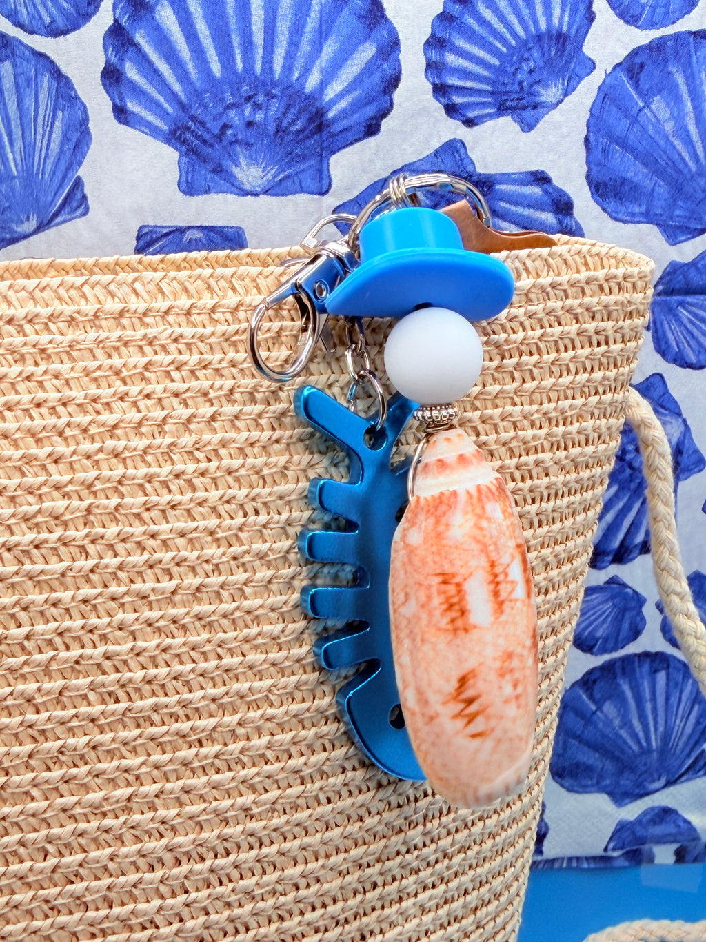 Lettered Olive fishbone bottle opener keychain with quarter for scale on blue background showing full keychain and SKU 2070 tag