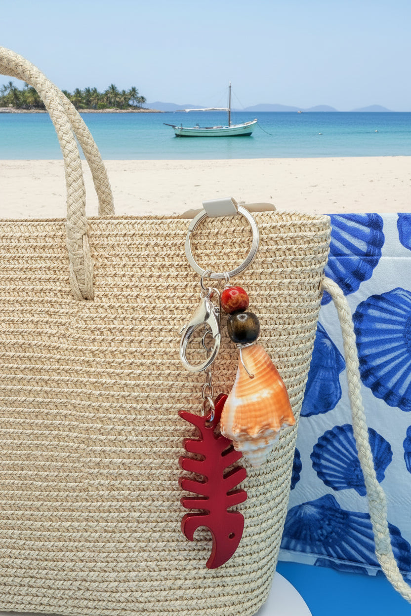Florida conch shell red fishbone bottle opener keychain on woven straw bag showing full length with blue floral background
