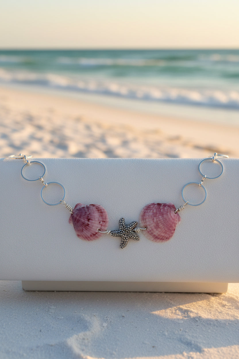 Purple calico scallop shell and starfish bracelet on white jewelry display stand showing full length