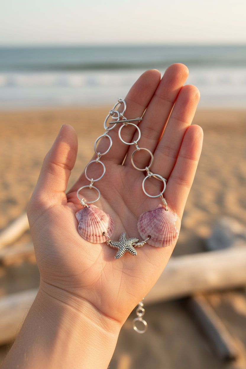 Purple calico scallop shell and starfish bracelet laid flat on blue background showing full circle link chain and toggle clasp