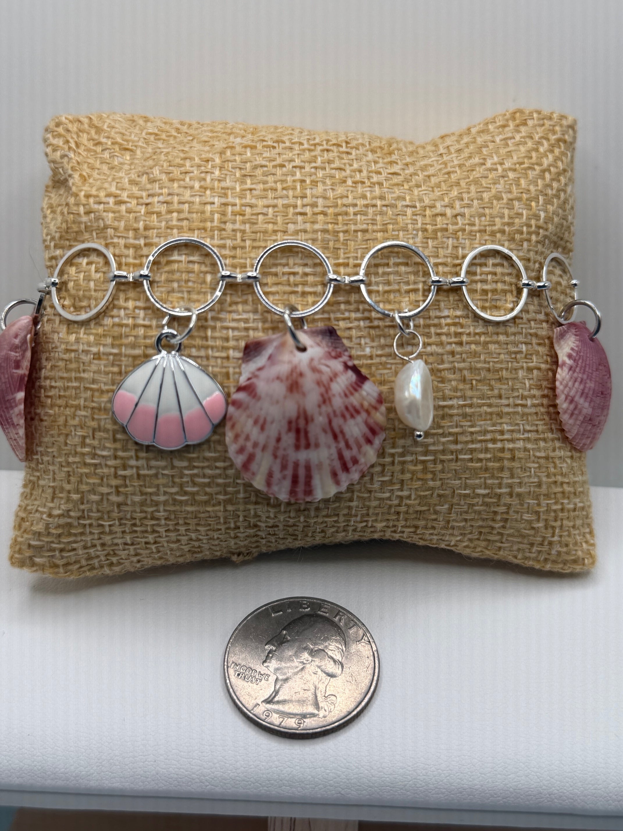 Shell charm bracelet close-up on burlap pillow