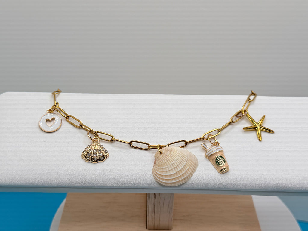 Ribbed venus clam shell charm bracelet on white display stand front view
