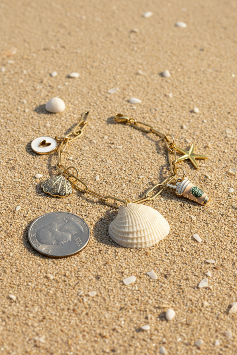 Ribbed venus clam shell charm bracelet on blue background with quarter for scale