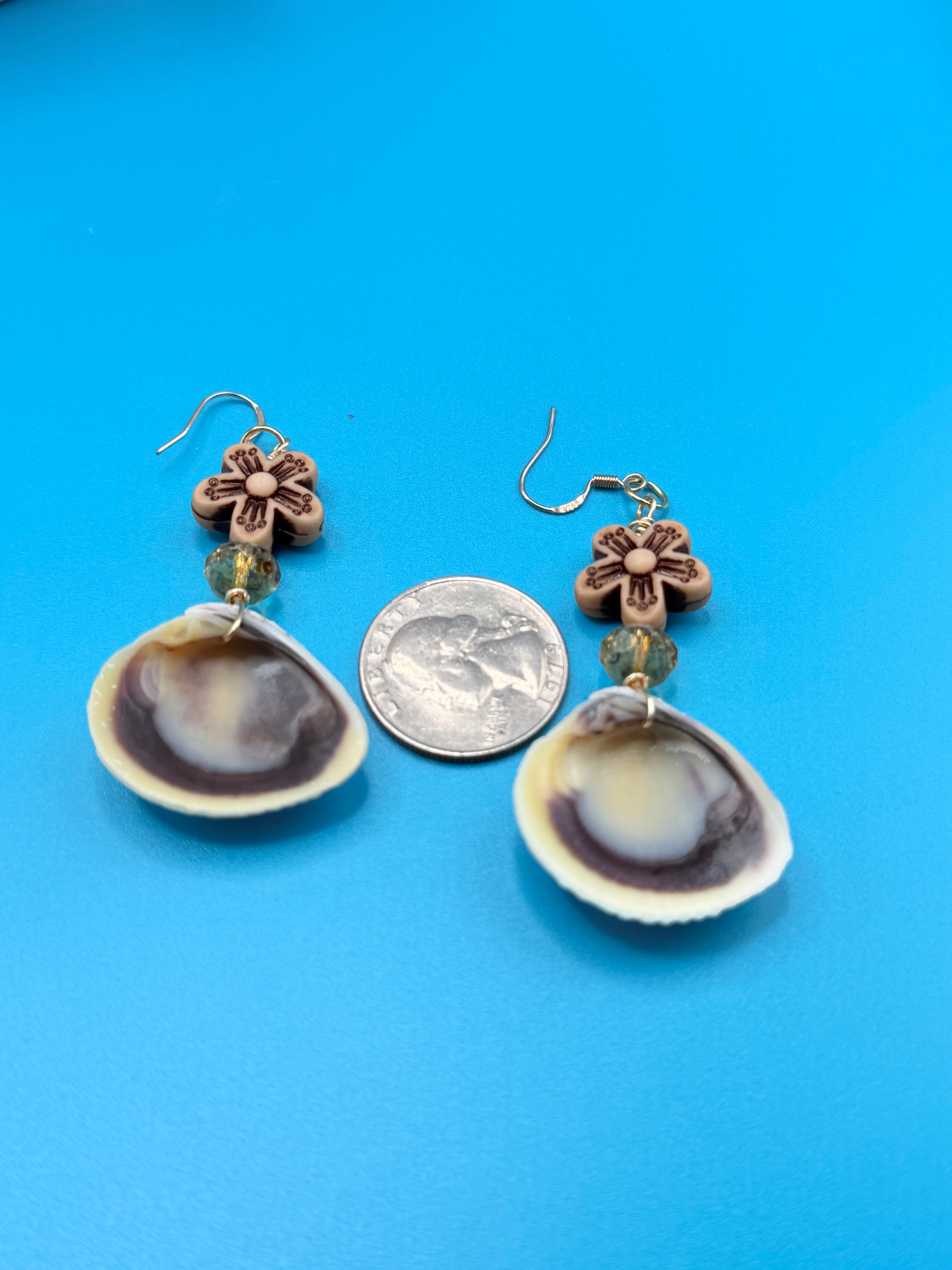 Pair of ribbed venus clam shell earrings on ruler showing 4 inch drop