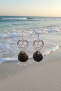 Pair of gray jingle shell double heart earrings on ruler showing full drop length front view