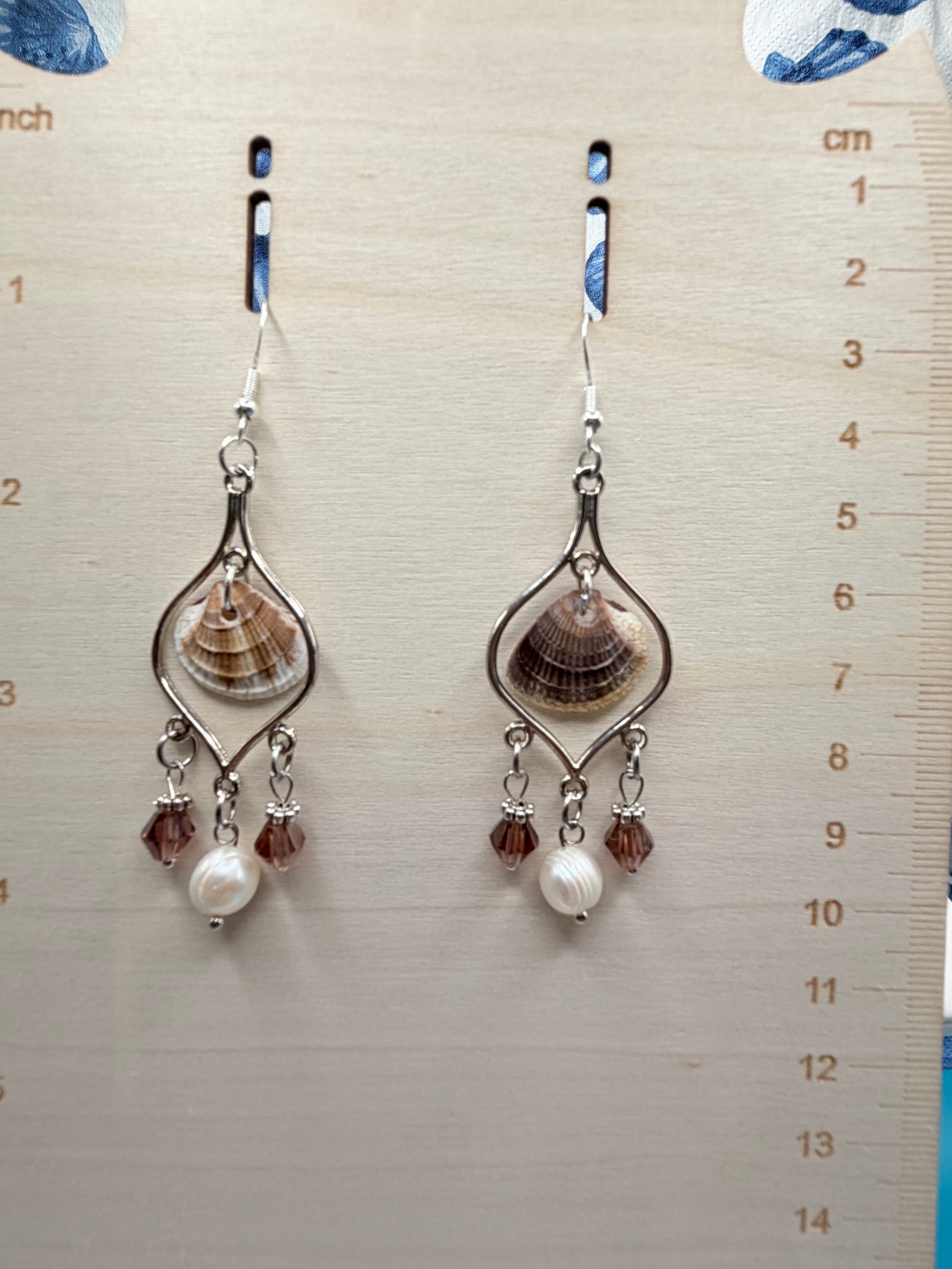 Pair of calico scallop shell chandelier earrings on ruler showing full drop