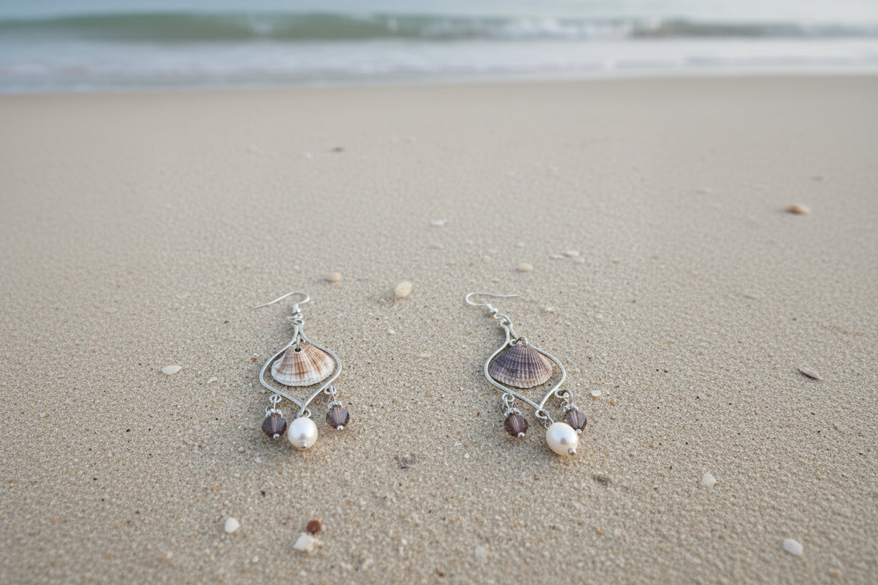 Single calico scallop shell chandelier earring on blue background with dime for scale