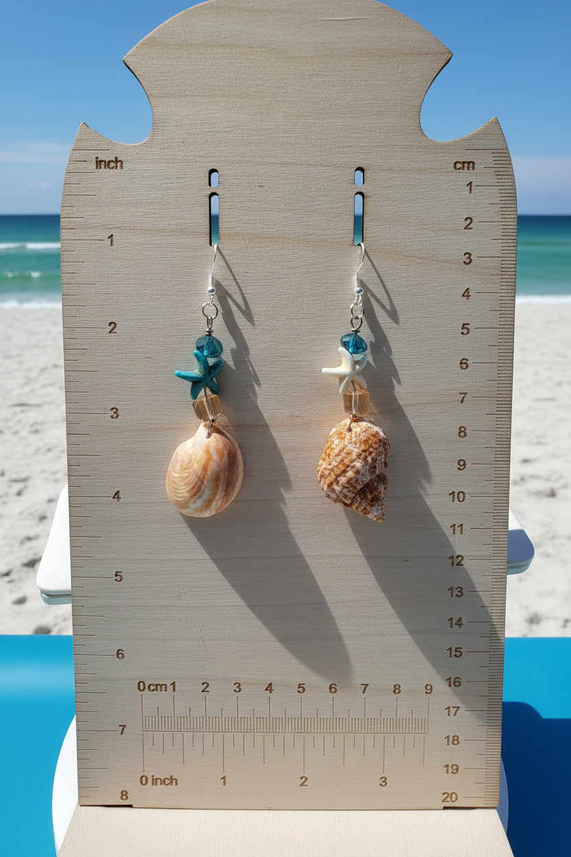 Mismatched turban and slipper shell earrings on display board close-up