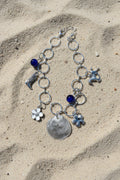 Jingle shell charm bracelet on white display stand