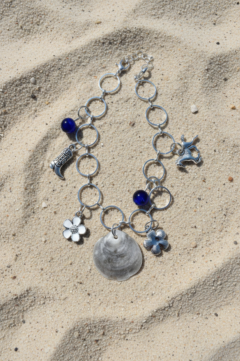 Jingle shell charm bracelet on white display stand