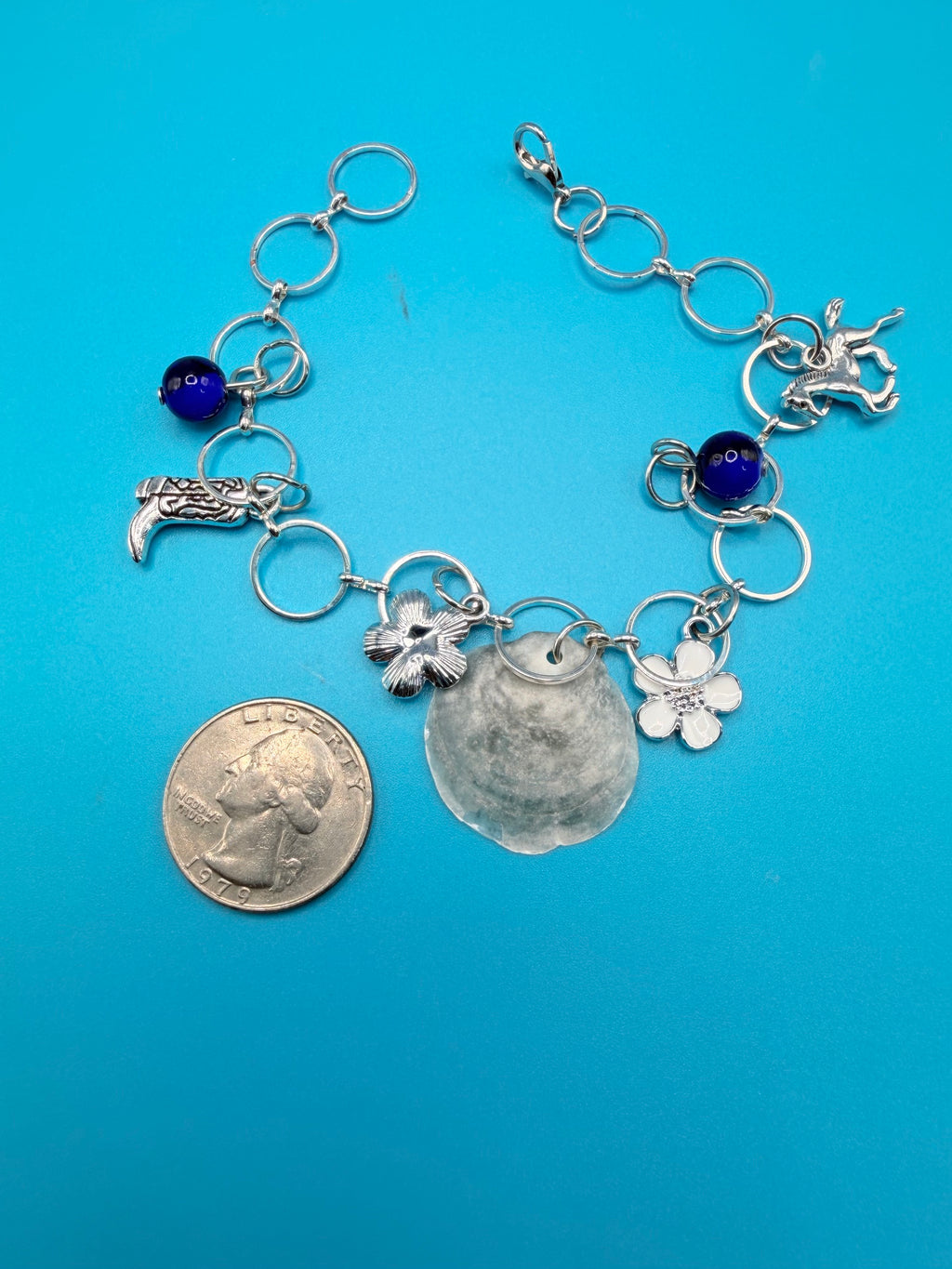 Jingle shell charm bracelet detail showing cobalt blue beads
