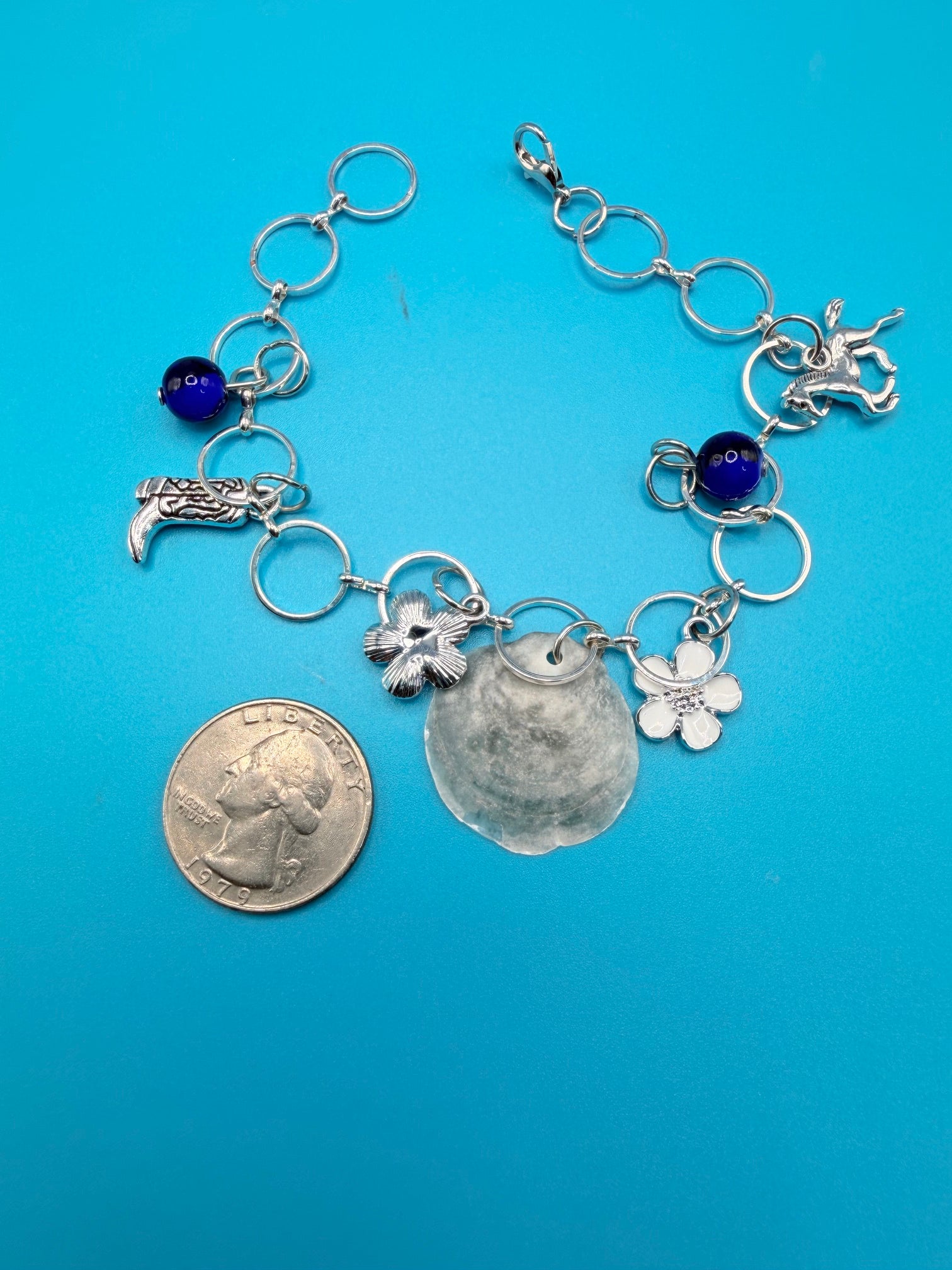 Jingle shell charm bracelet detail showing cobalt blue beads