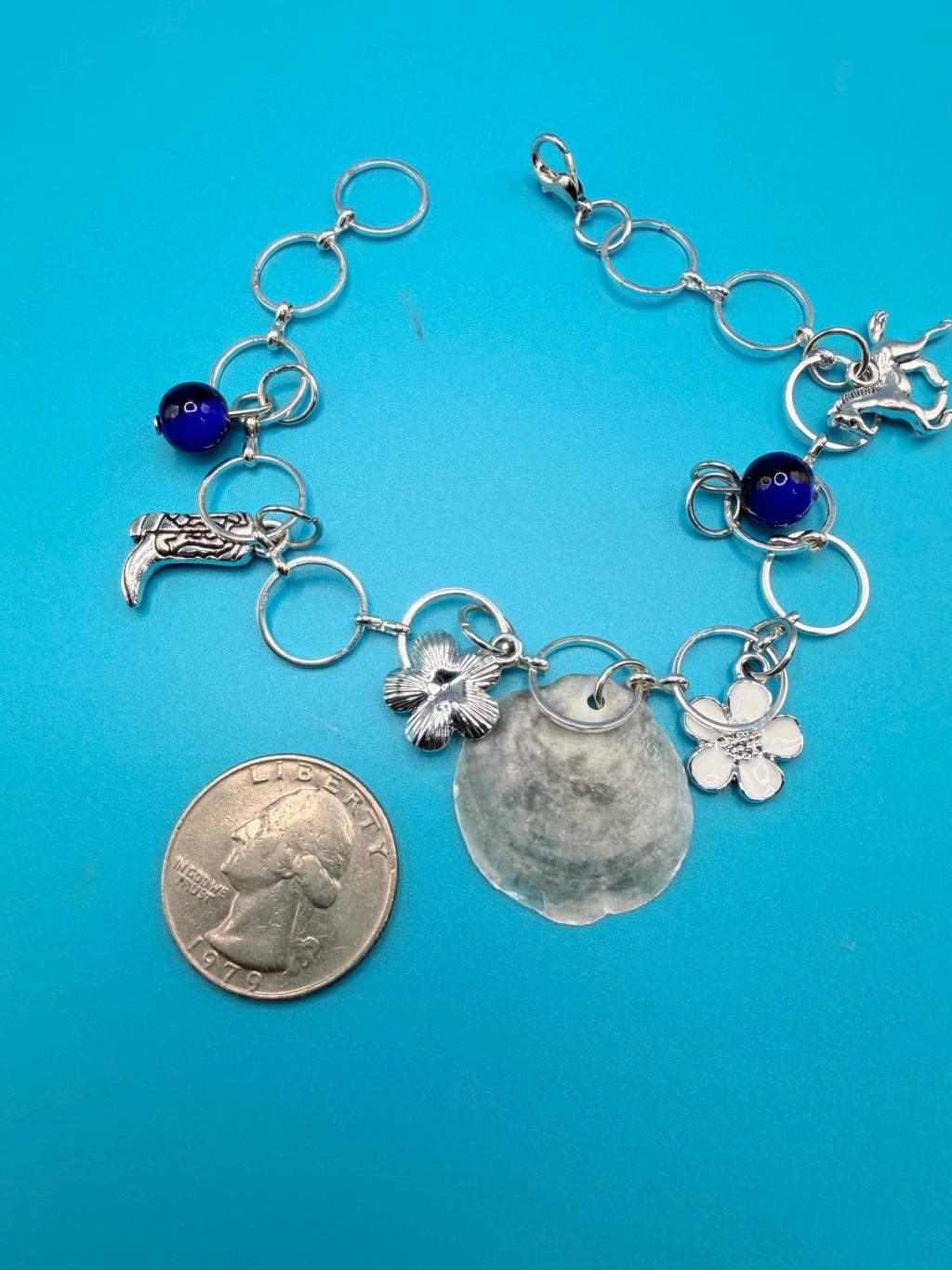 Jingle shell charm bracelet on straw hat overhead view