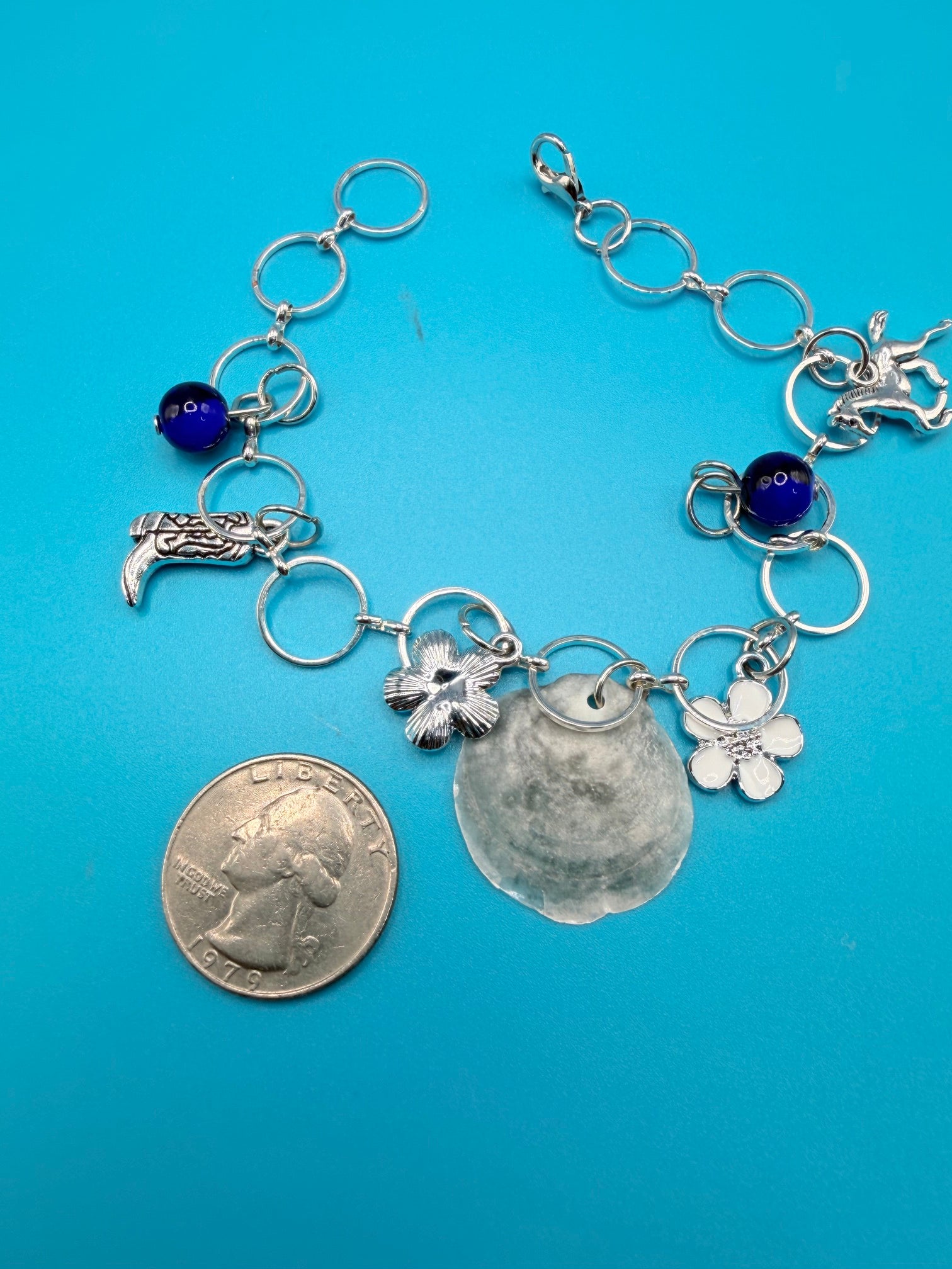 Jingle shell charm bracelet on straw hat overhead view