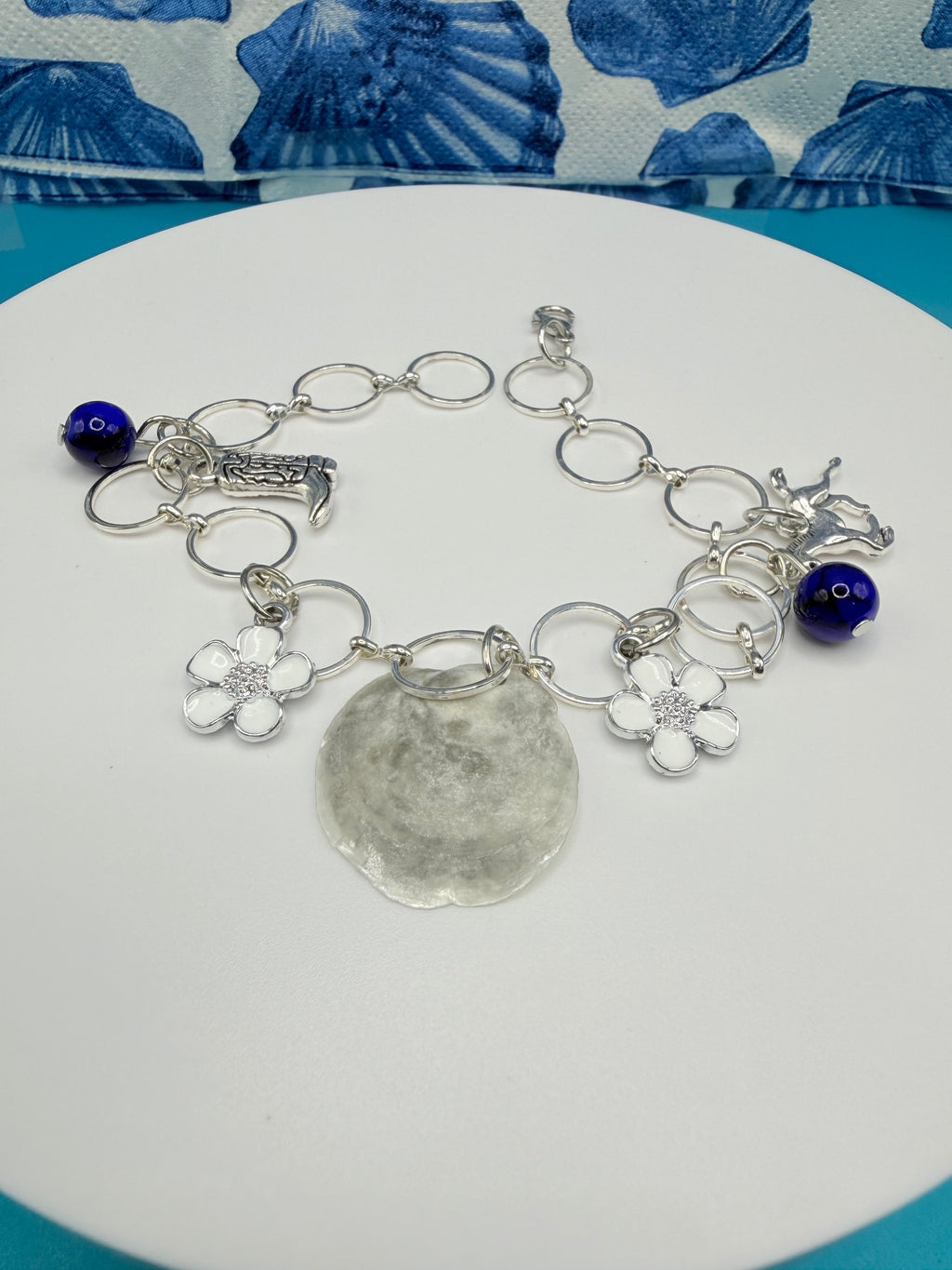 Jingle shell charm bracelet on straw hat showing all charms