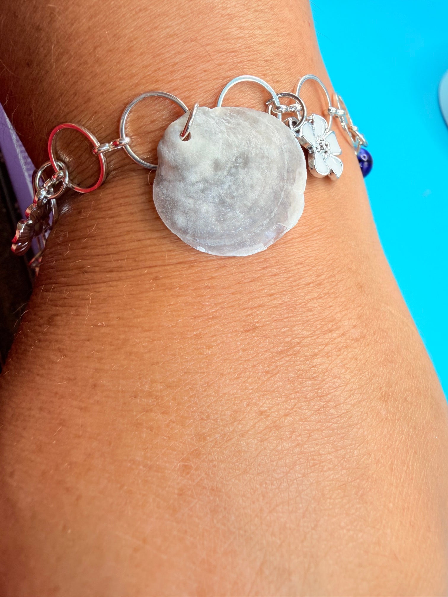 Jingle shell charm bracelet on straw hat side view