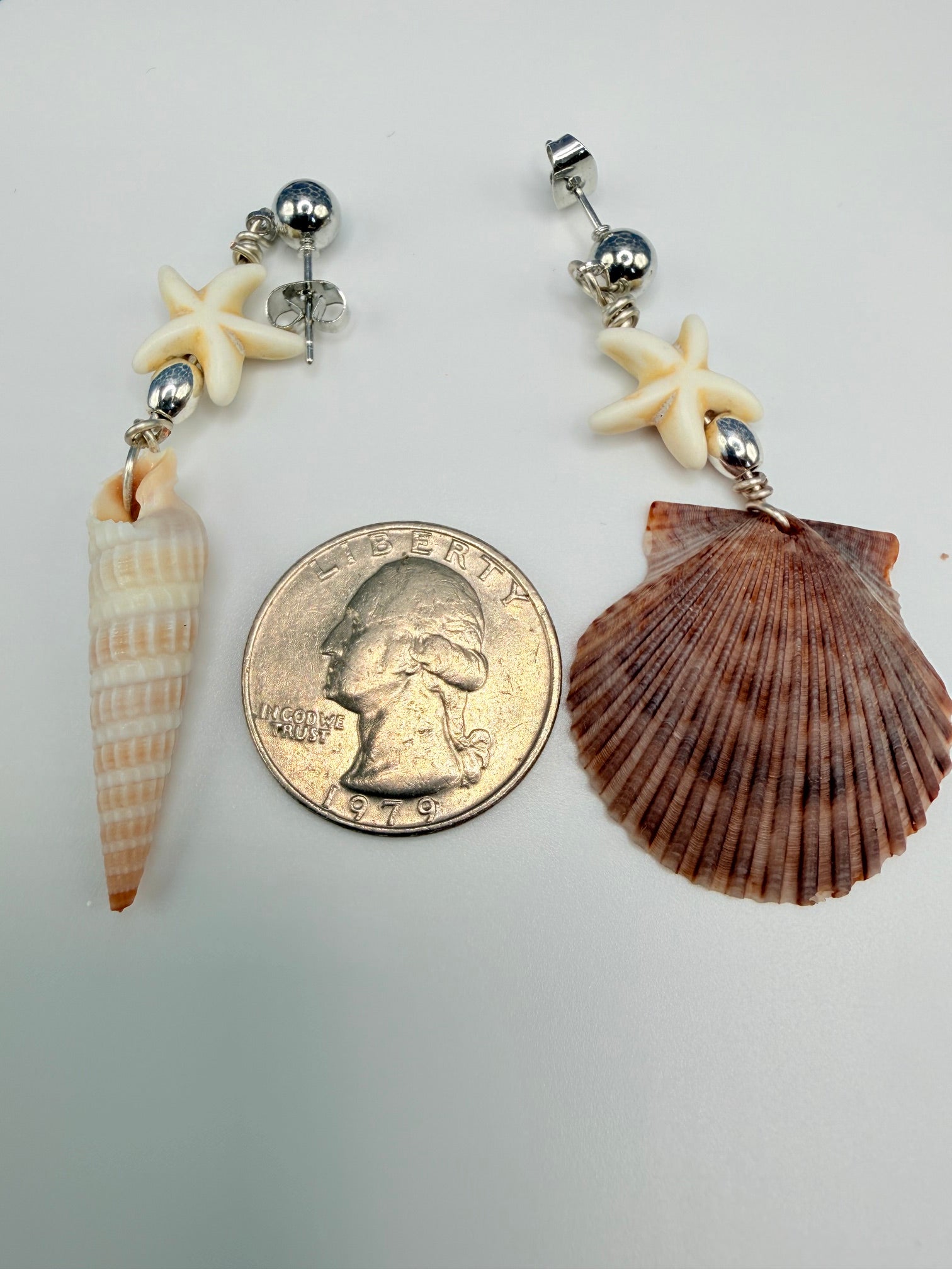 Close-up of scallop shell earring on ruler showing size