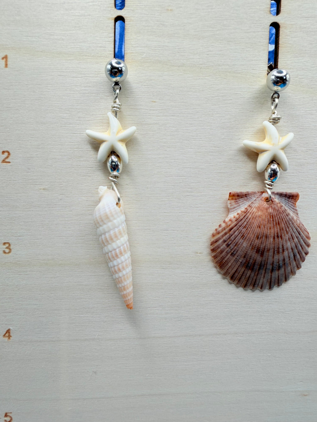 Mismatched shell earrings on ruler showing full length
