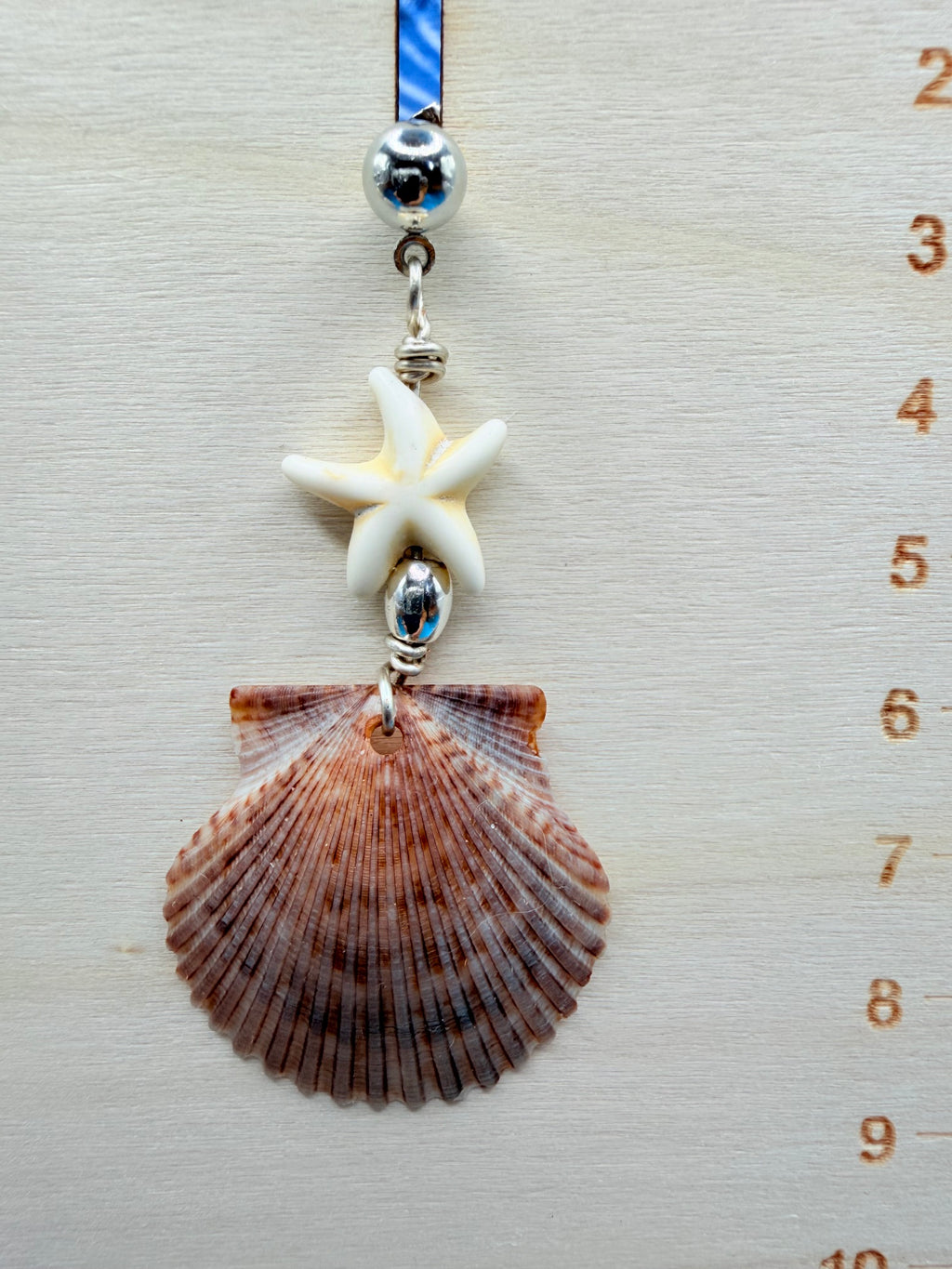 Mismatched shell earrings on ruler side view