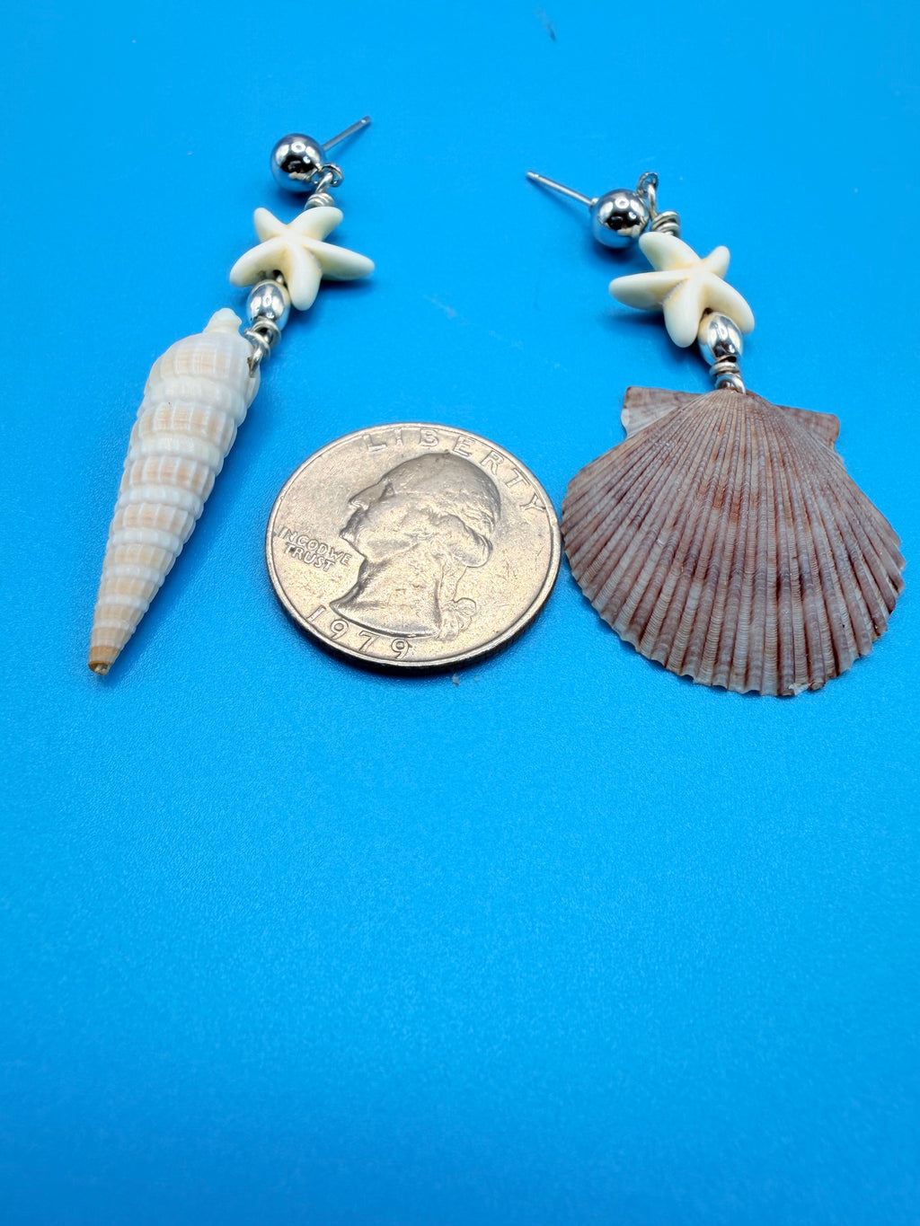 Mismatched scallop and auger shell earrings on ruler showing drop length