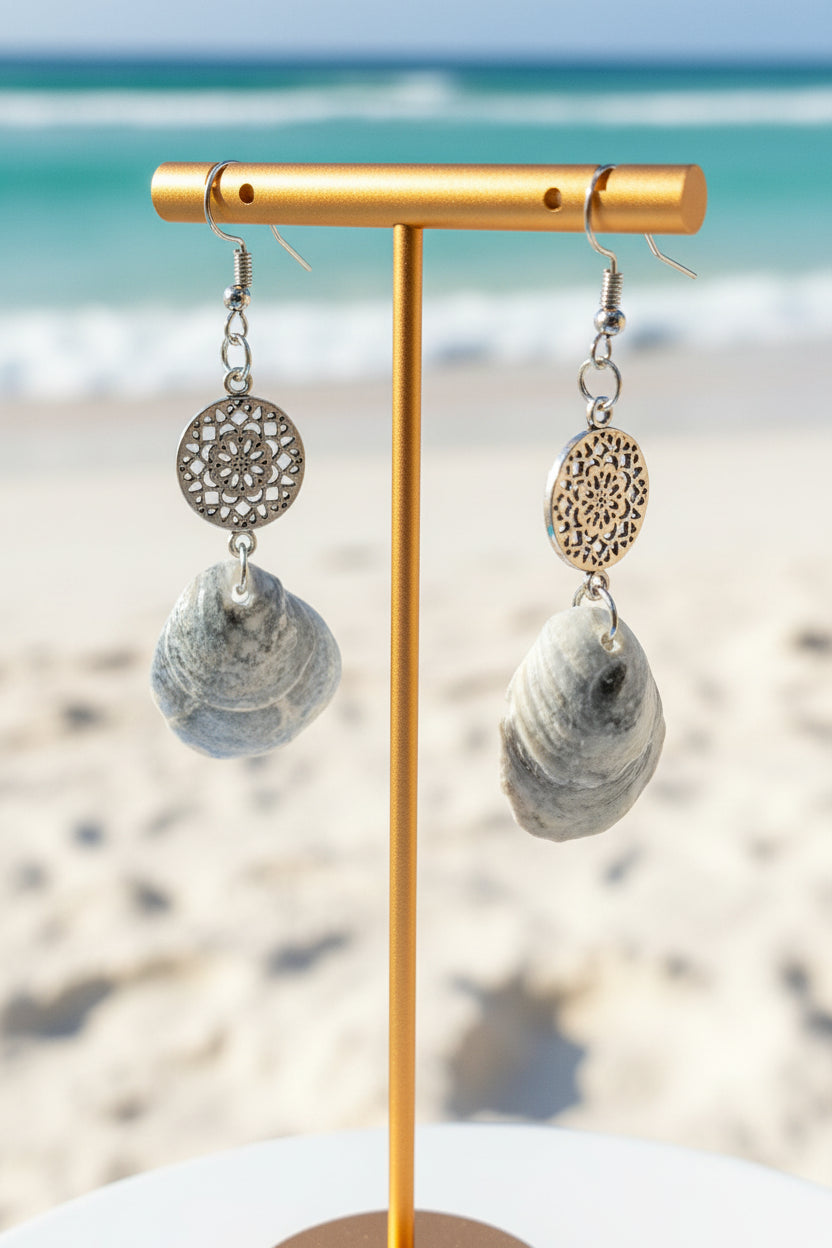Jingle shell earring on wooden ear display with ruler showing approximately 2 inch length