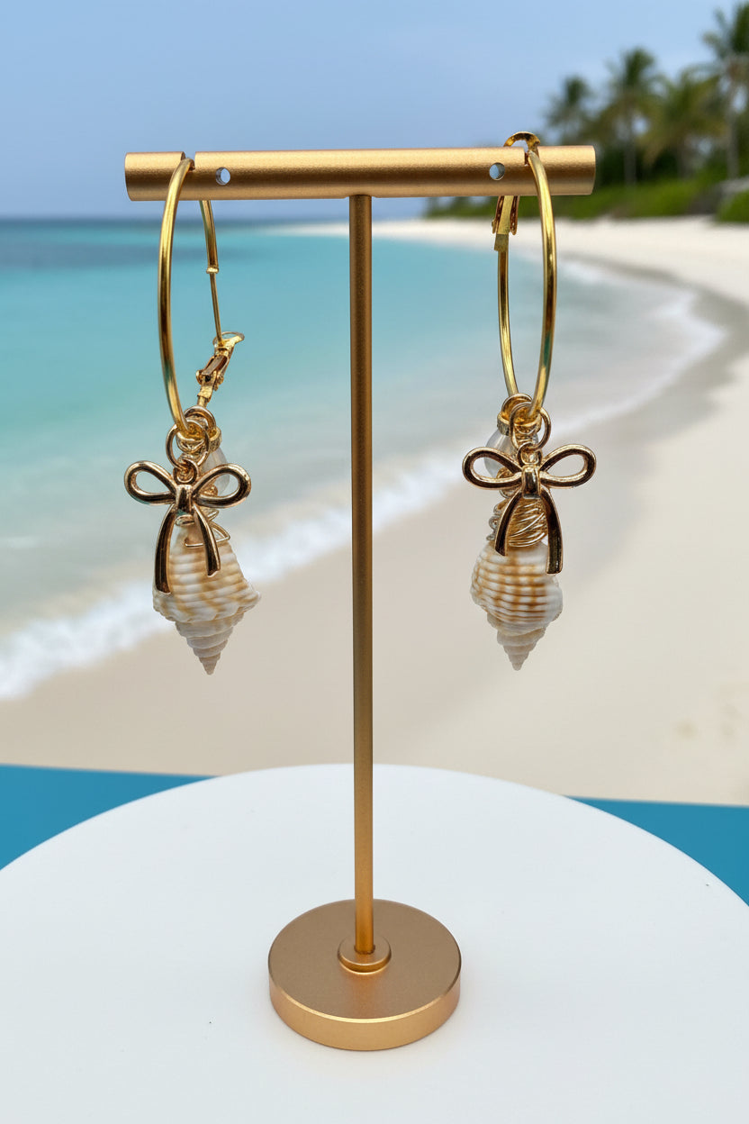 Juvenile conch shell hoop earring close-up with quarter for scale