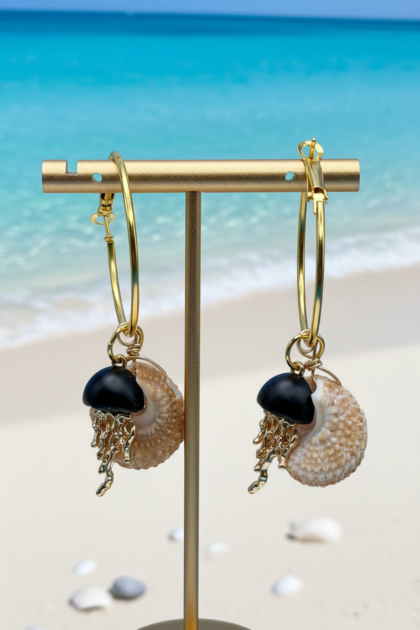 Single turban shell hoop earring flat lay on white surface with shell background