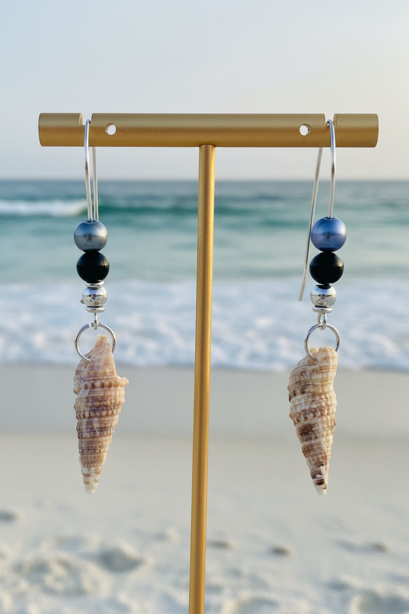 Auger shell earrings pair on blue background