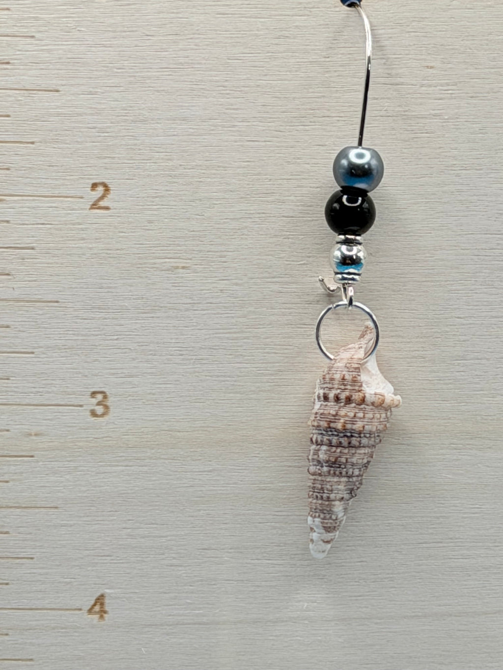 Auger shell earrings length measurement on ruler board